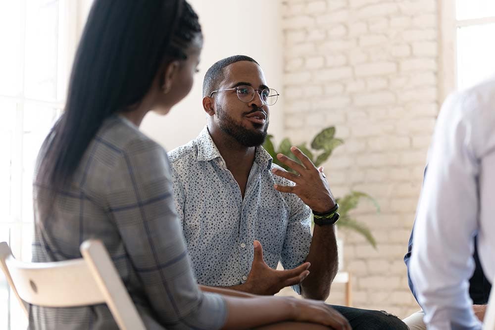 a man talking to his peers in a group therapy session