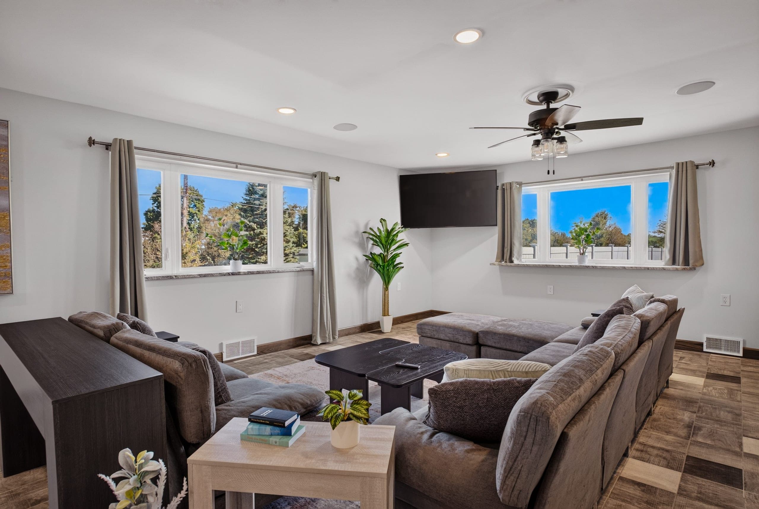 A living room with a sectional sofa and wide windows