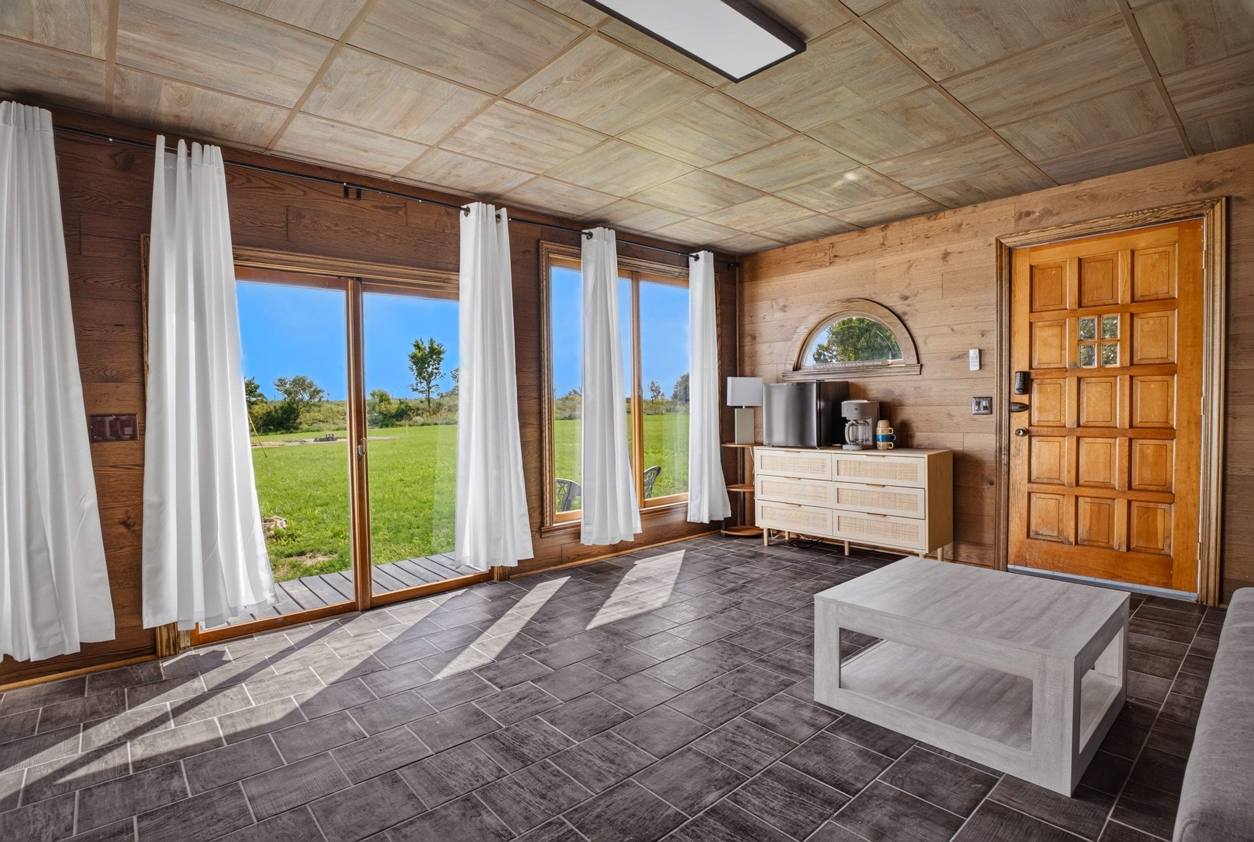 A sunroom with glass doors opening onto the lawn