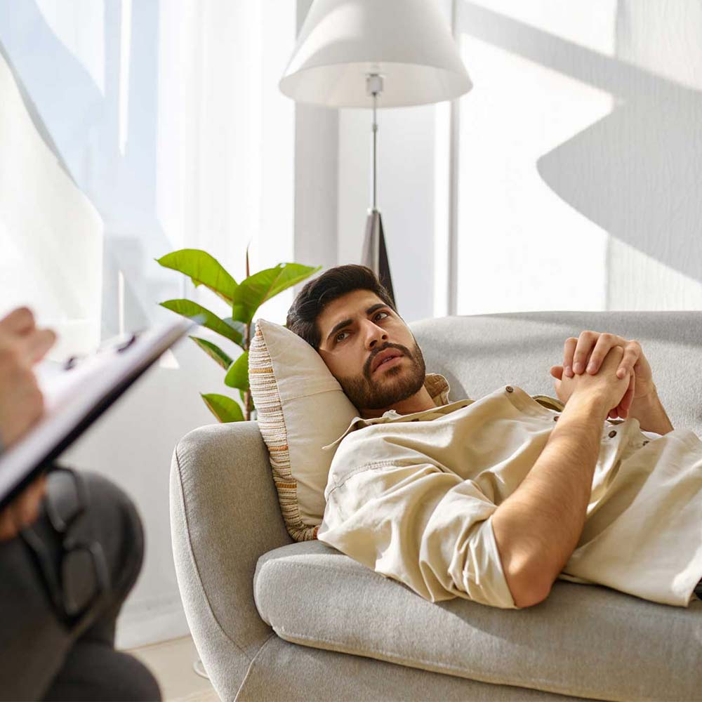 dbt-for-addictiong a man laying down on a couch talking to a DBT therapist for addiction